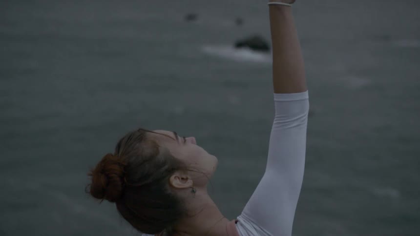 A woman stretches on the beach