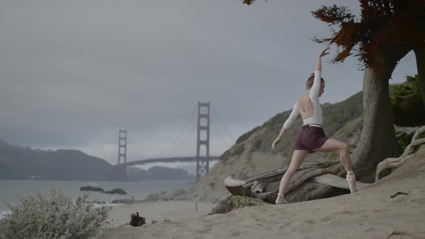 A woman practicing dancing at a beach