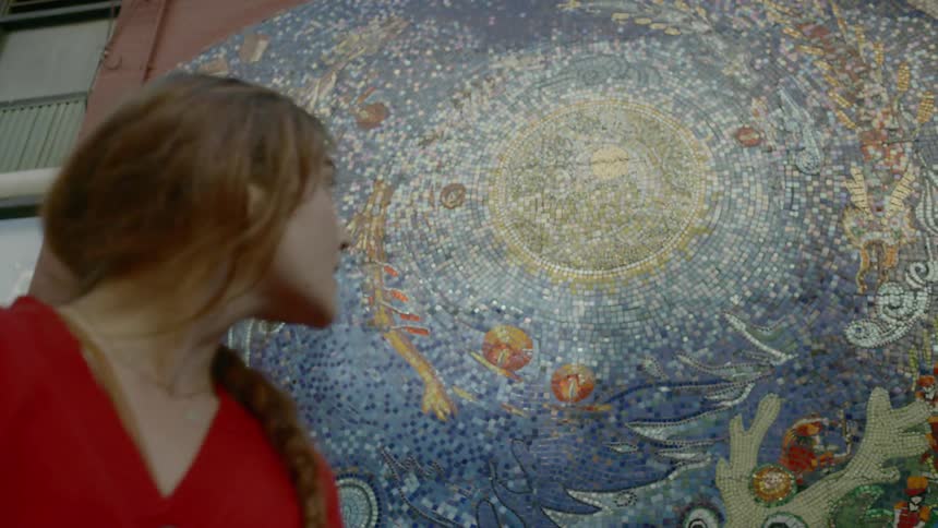 Woman smiles while studying mural