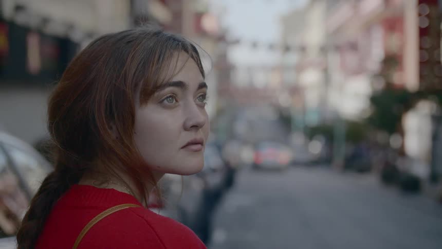 A woman standing in the street looking off in the distance
