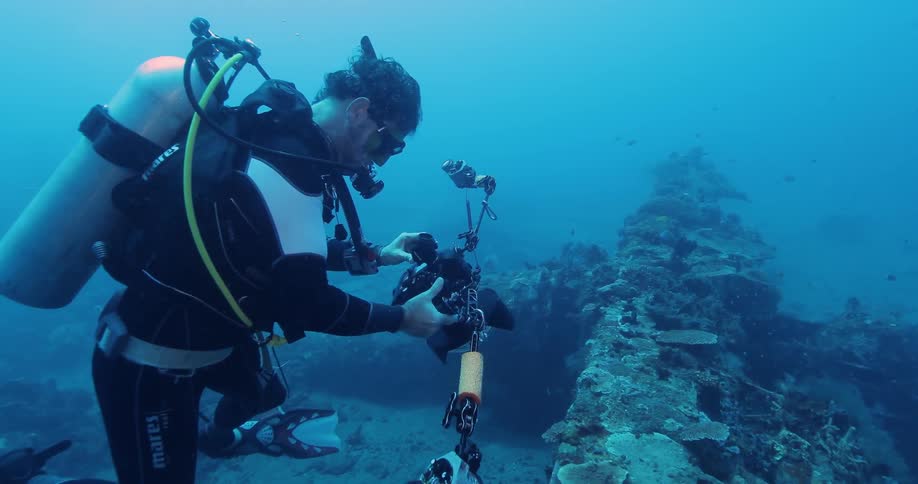 A scuba diver taking pictures underwater