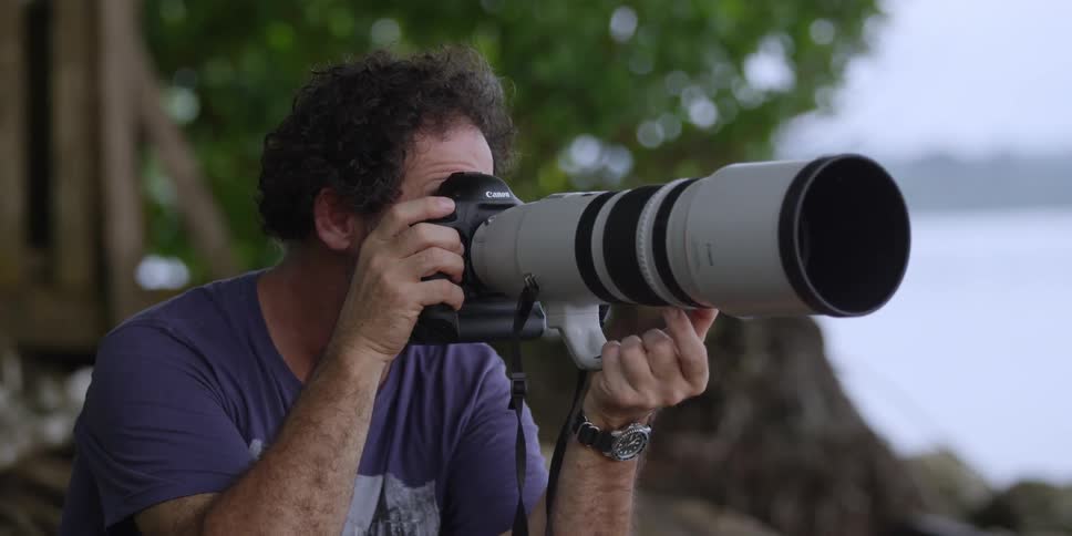 A photographer with a large lens takes a picture