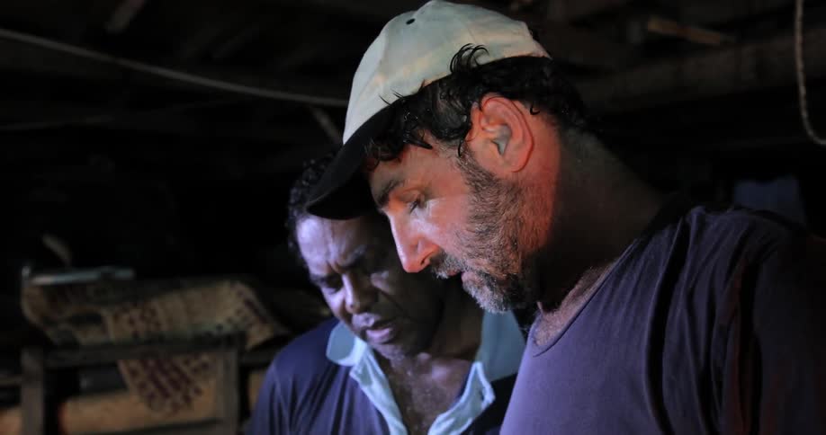 Two men stand together in discussion