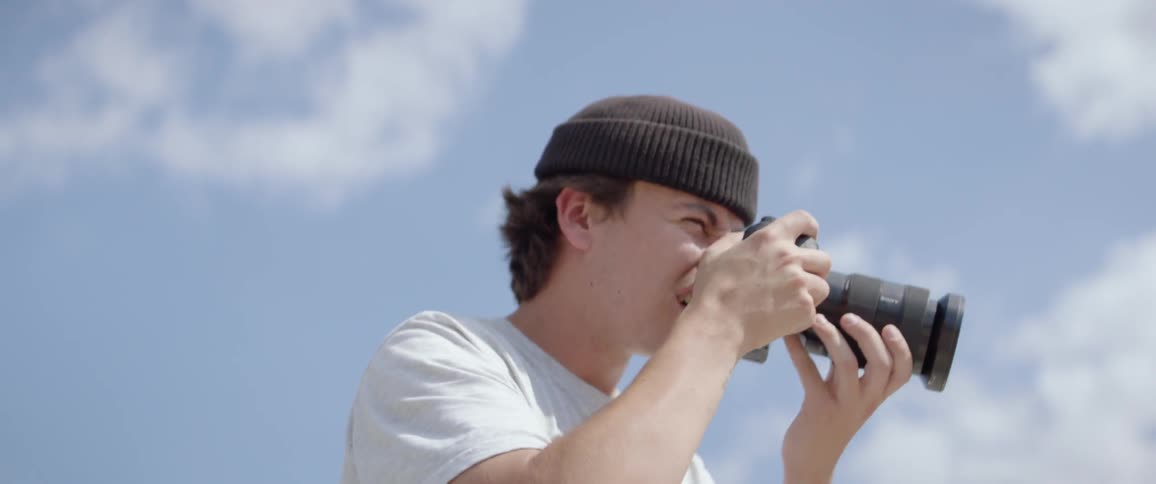 A male teenager takes pictures with a camera