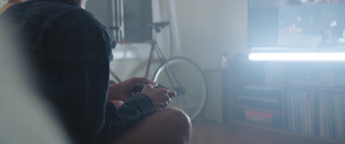 A pair of people sitting on a sofa playing a video game together