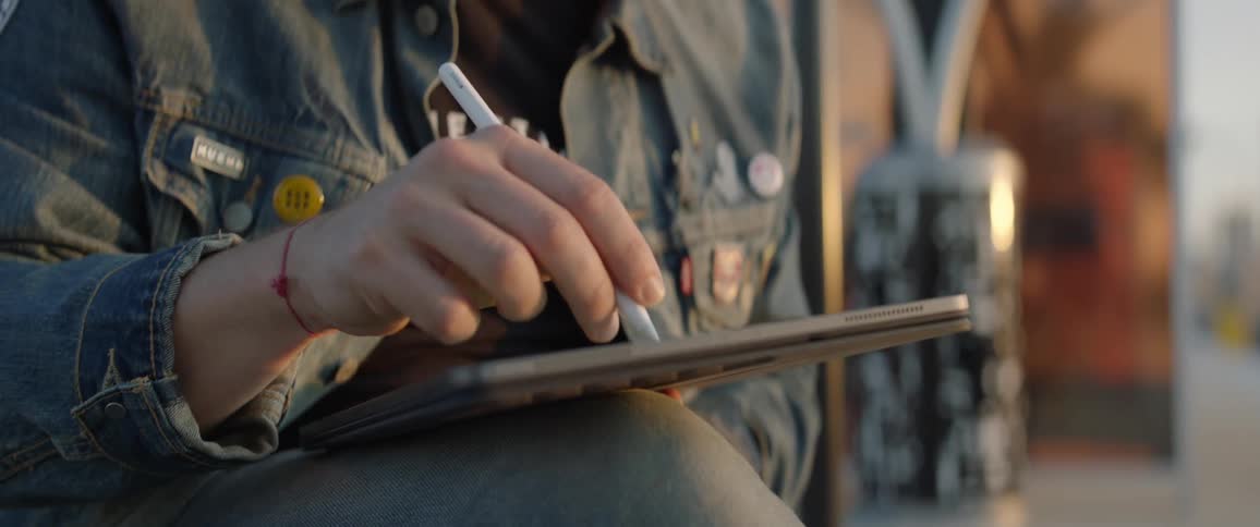 Man sitting on the beach uses a tablet with a stylus at the railway station