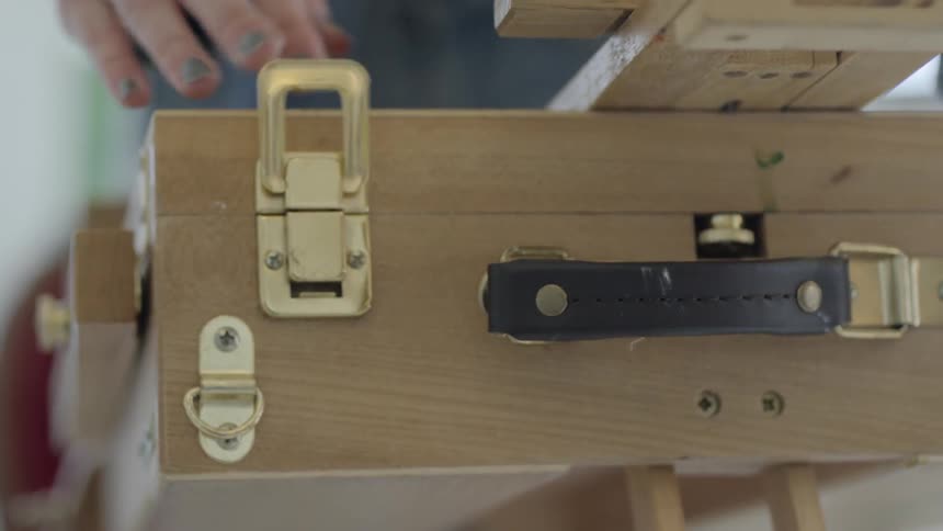 Woman opens artist easel box