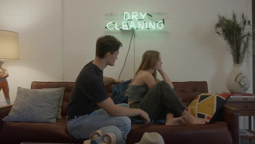 Man tries to make up with blonde girl who is cross with him in the living room