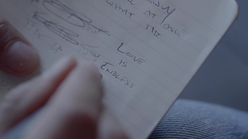 Man writes down on a notebook about love during daylight