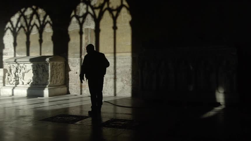 A man walks down the dark hall