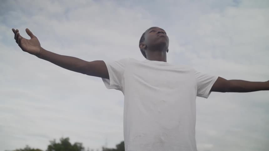 A man raises his arms into the sky