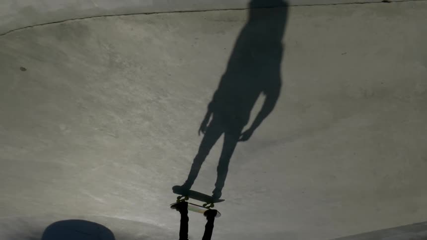 A skateboarder rides in a skatepark
