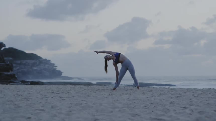 A woman during stretches on the beach