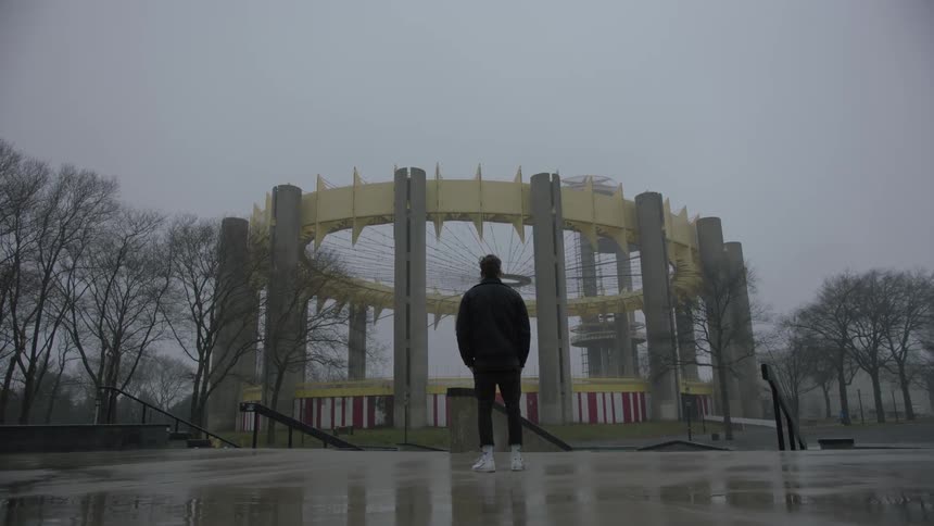 A man stands outside and looks at a building