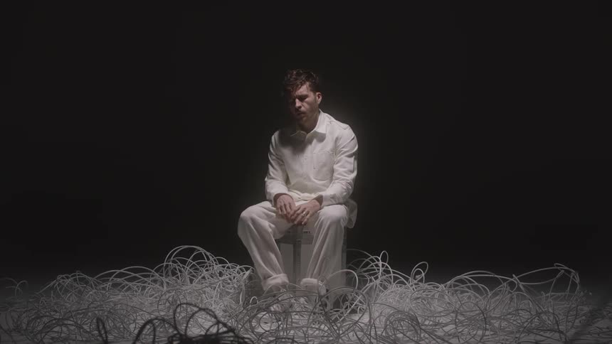 A person sits in the middle of lots of wires