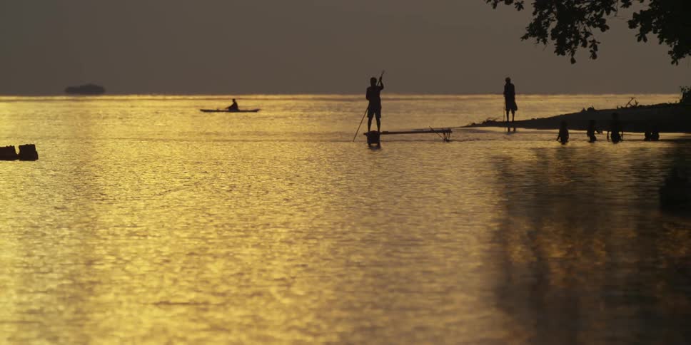 People on a lakefront at sunset