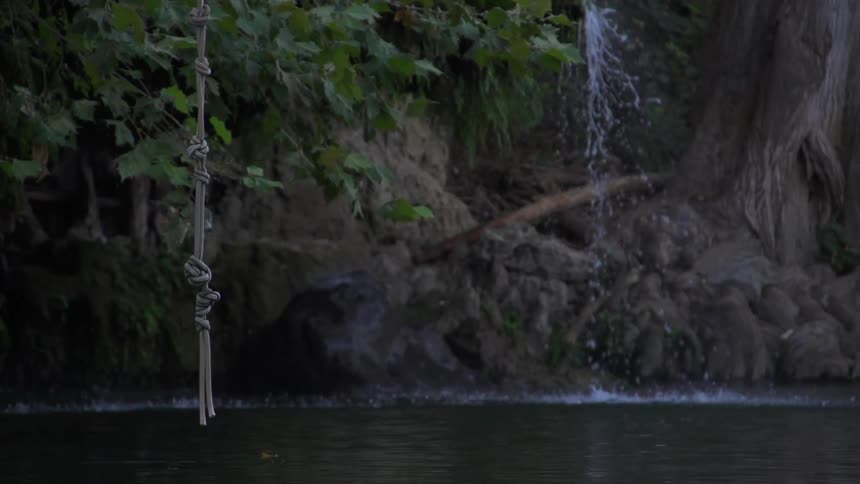 A waterfall behind a knotted rope