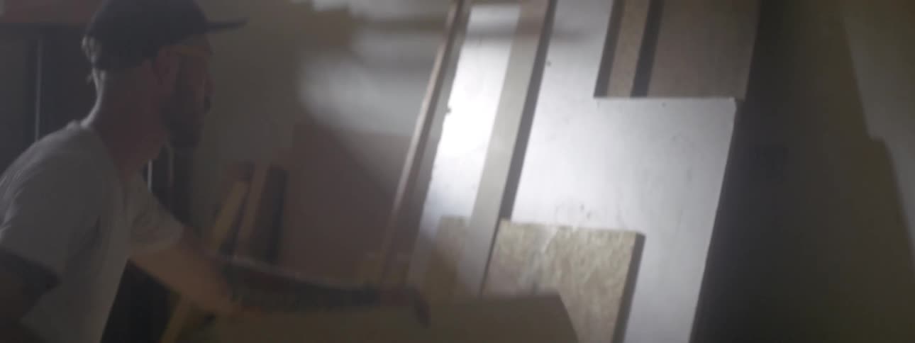 A man grabs a wood box and lays it on a table