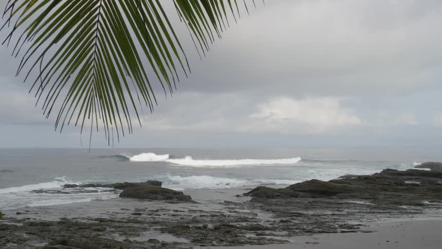 Waves roll into shore under a dark cloudy sky