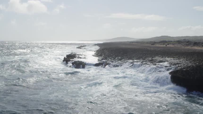Ocean swells crashing into rocky coastline
