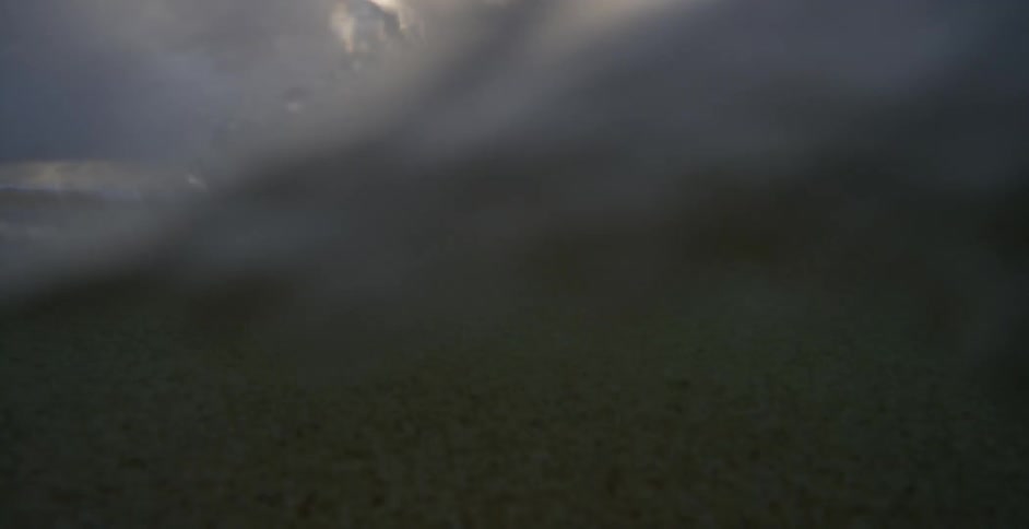 A wave rolls in from the ocean