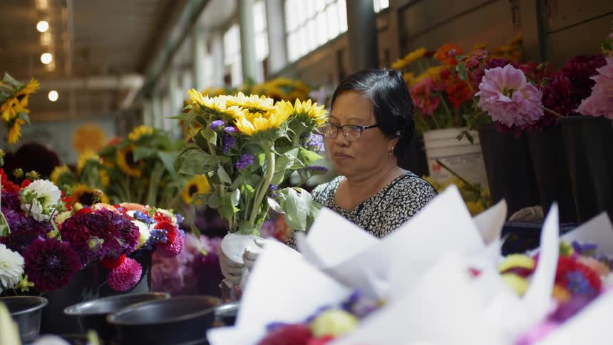 Flower seller arranges bouquet buckets
