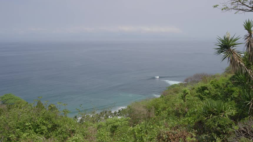 The green hill leads to the beach