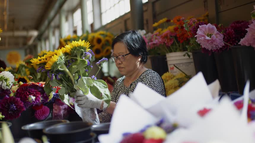 A woman works with flowers indoors