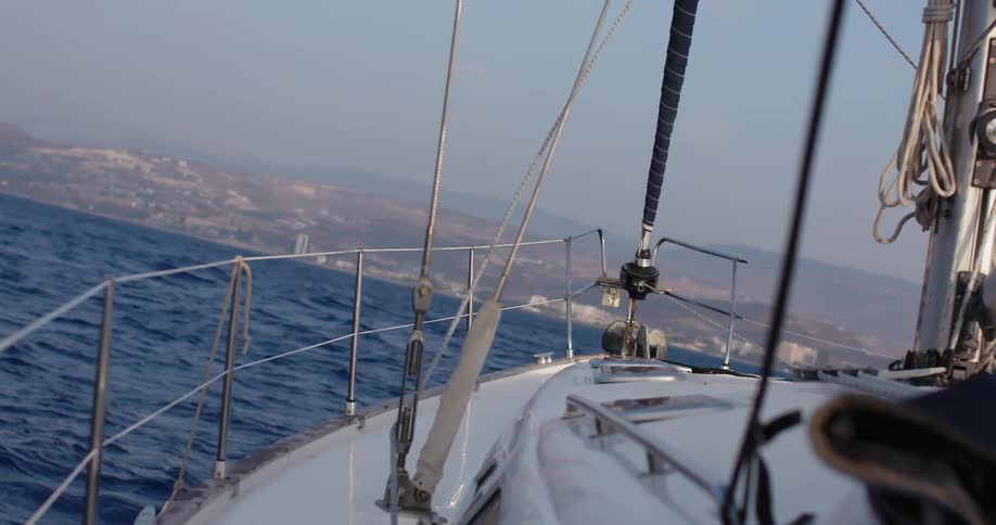 Boat sailing in the ocean near coast on a clear day