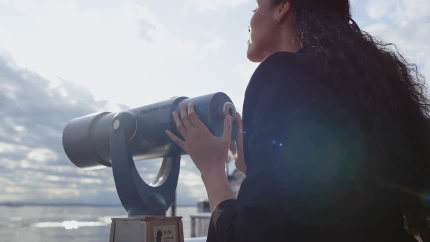 A woman is looking through binoculars