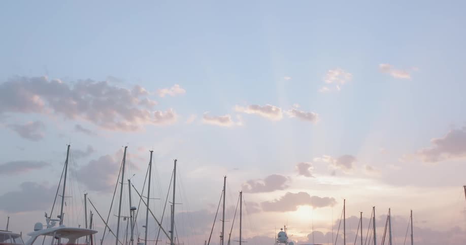 The sun rises over a pier with many parked boats