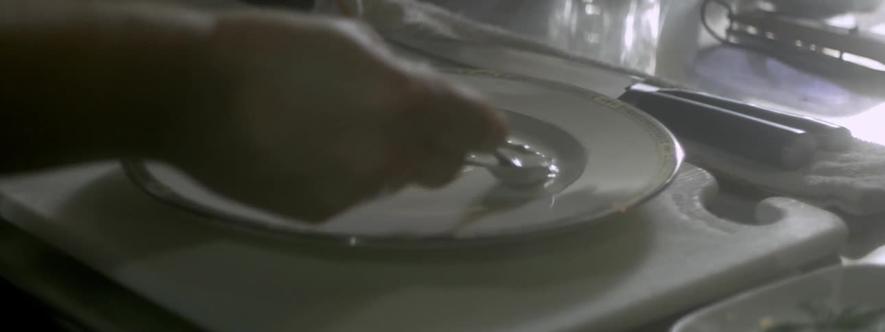 A man artfully places some type of cream onto a plate