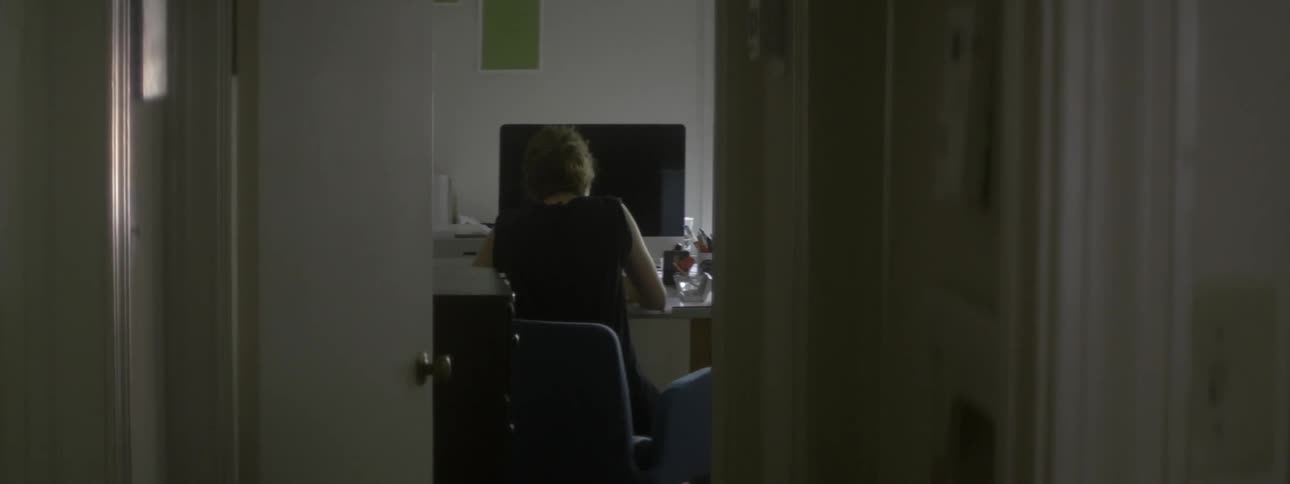 A woman sits working at a desk