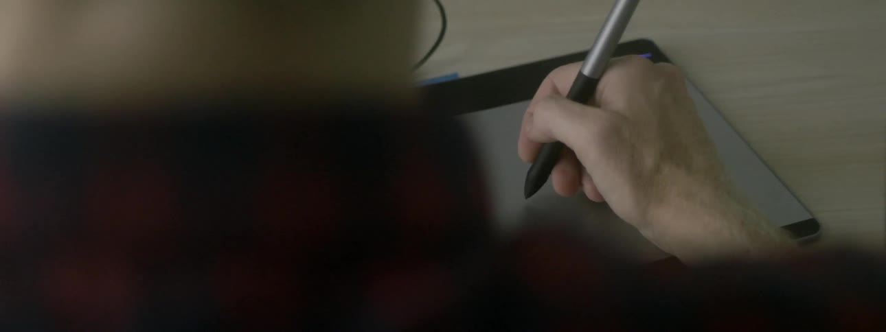A man using a stylus on a writing board