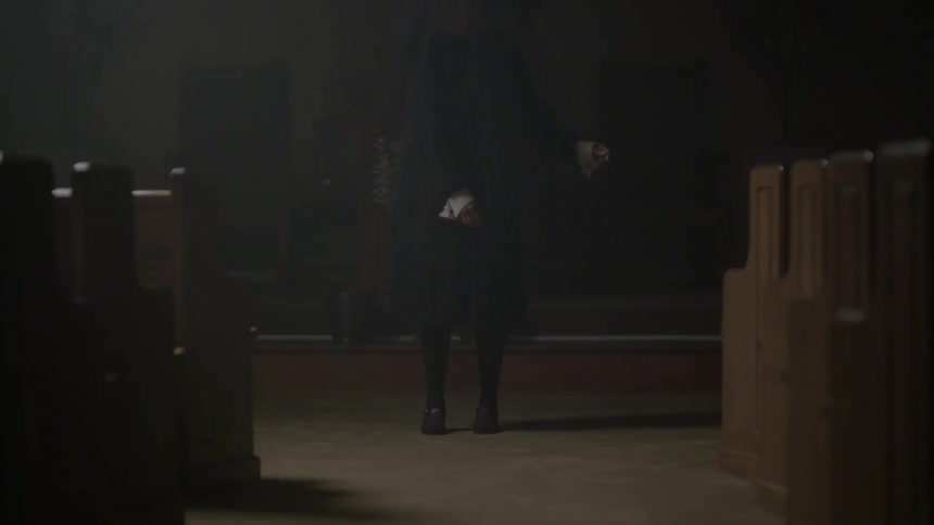 A person in black sways in a church