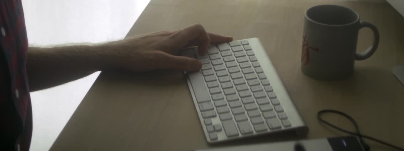 Someone drawing on a touch pad next to a keyboard