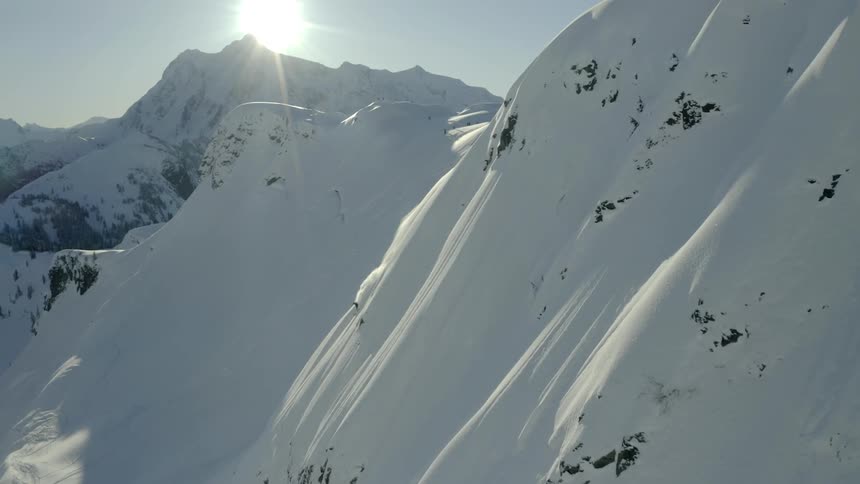 A steep mountainside covered in thick snow