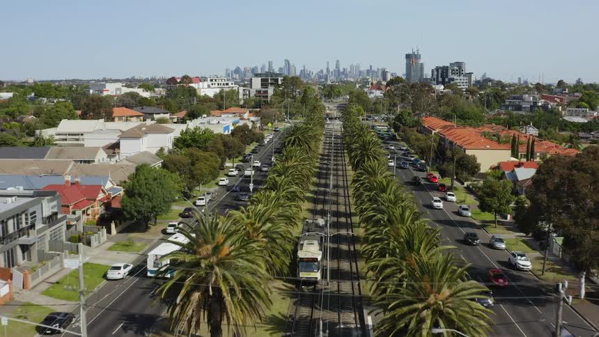 Buses trolleys and cars travel the road of a small town