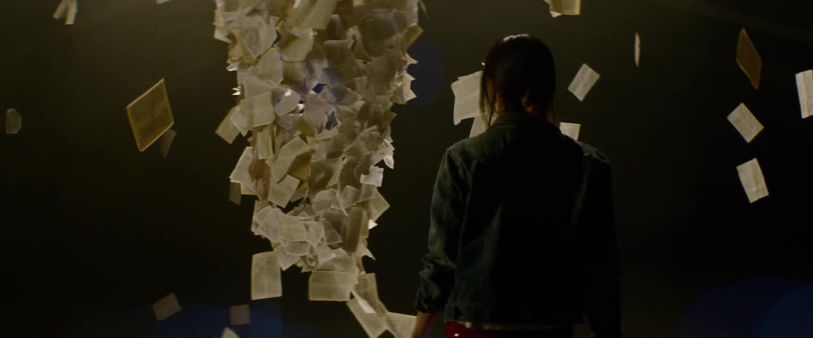 An art installation containing postcards and pages of text suspended from the ceiling