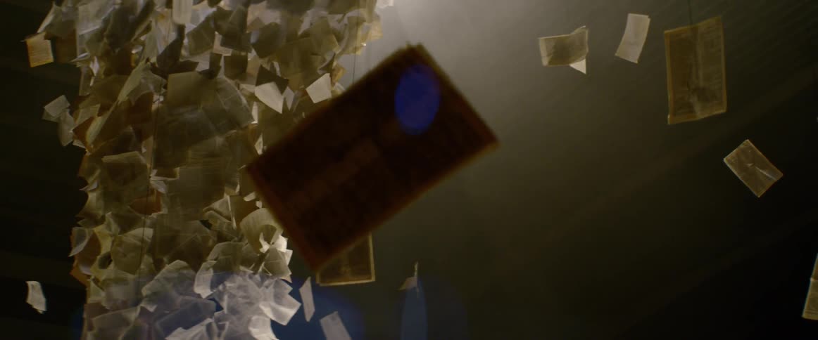 An art installation containing postcards and pages of text suspended from the ceiling