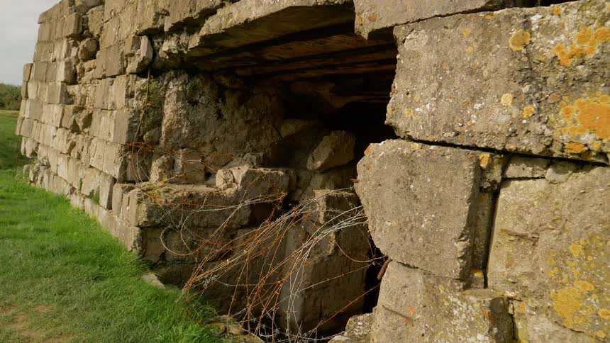 A hole leading into the dark innards of a dilapidated stone wall