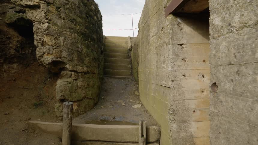 The camera moves through a cement bunker