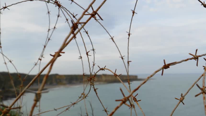 A close up footage of a barbed wire near the beach