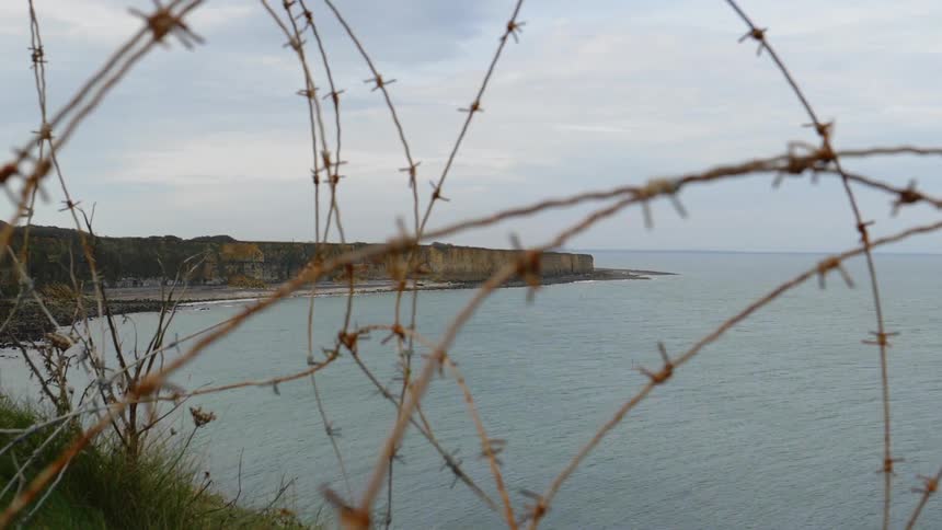 A scenery of a coastal on the cloudy days behind the fence