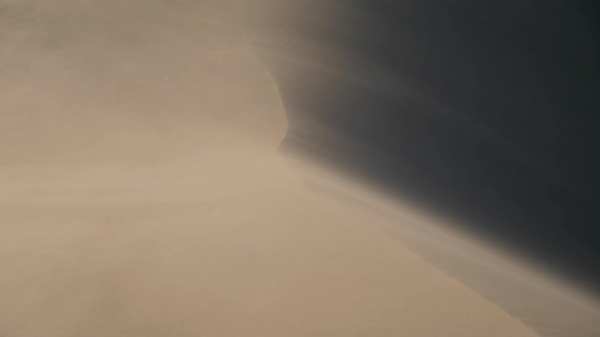 Dust blowing over a sand dune in the desert