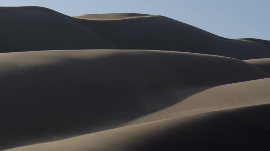 Sand dunes are displayed in a desert area