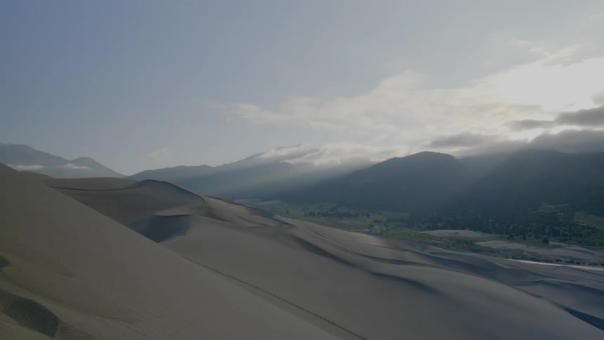 A mountain range with the sky and clouds in the background
