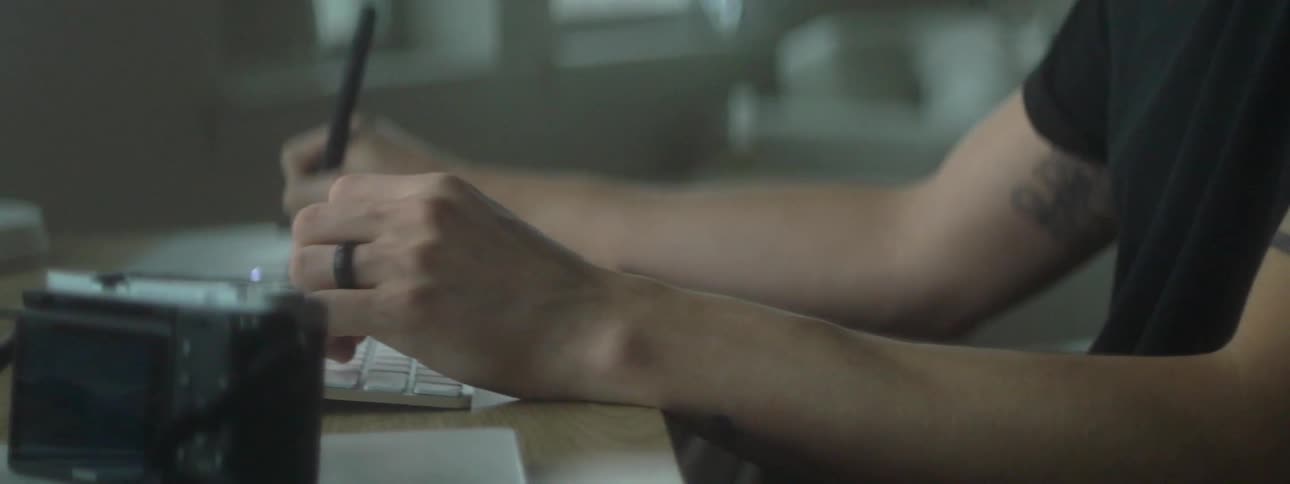A person writes next to their keyboard