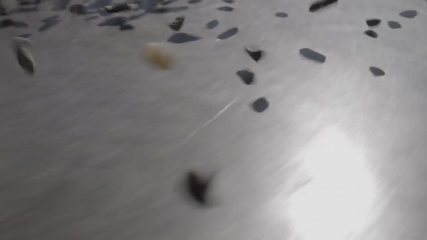 Rocks bounce on the ground as seen from a moving vehicle