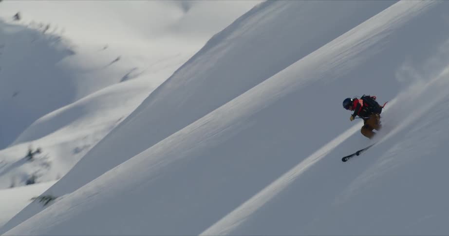 A skillful skier makes their way down a very steep snow covered slope